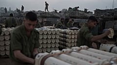 Israeli soldiers from the artillery unit store tank shells in a staging area at the Israeli-Gaza border in southern Israel