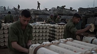 Israeli soldiers from the artillery unit store tank shells in a staging area at the Israeli-Gaza border in southern Israel