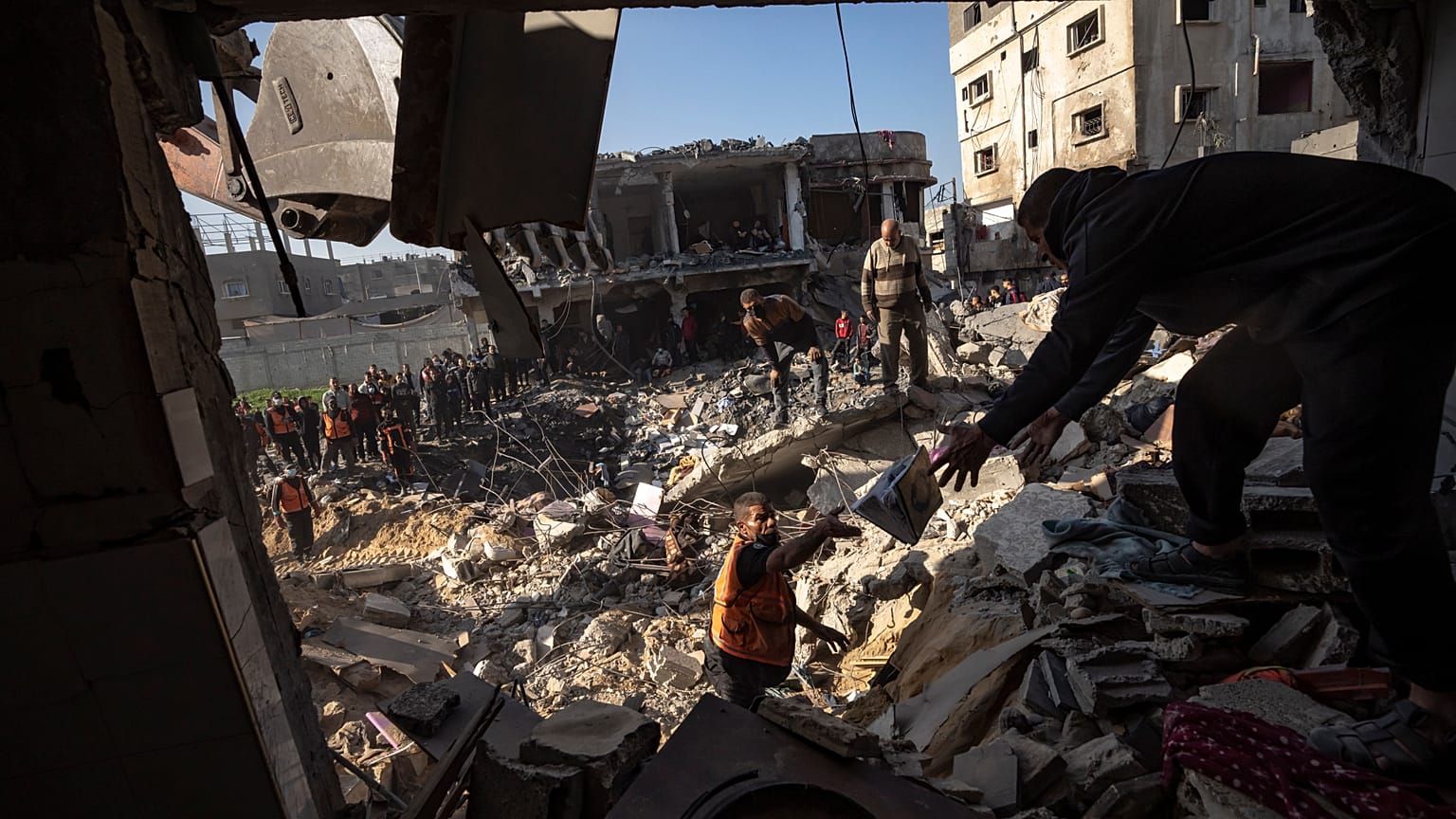فلسطينيون يبحثون عن جثث وناجين تحت أنقاض مبنى سكني دمرته غارة جوية إسرائيلية في رفح جنوب قطاع غزة، الثلاثاء 19 ديسمبر 2023