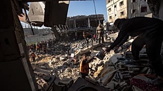 فلسطينيون يبحثون عن جثث وناجين تحت أنقاض مبنى سكني دمرته غارة جوية إسرائيلية في رفح جنوب قطاع غزة، الثلاثاء 19 ديسمبر 2023