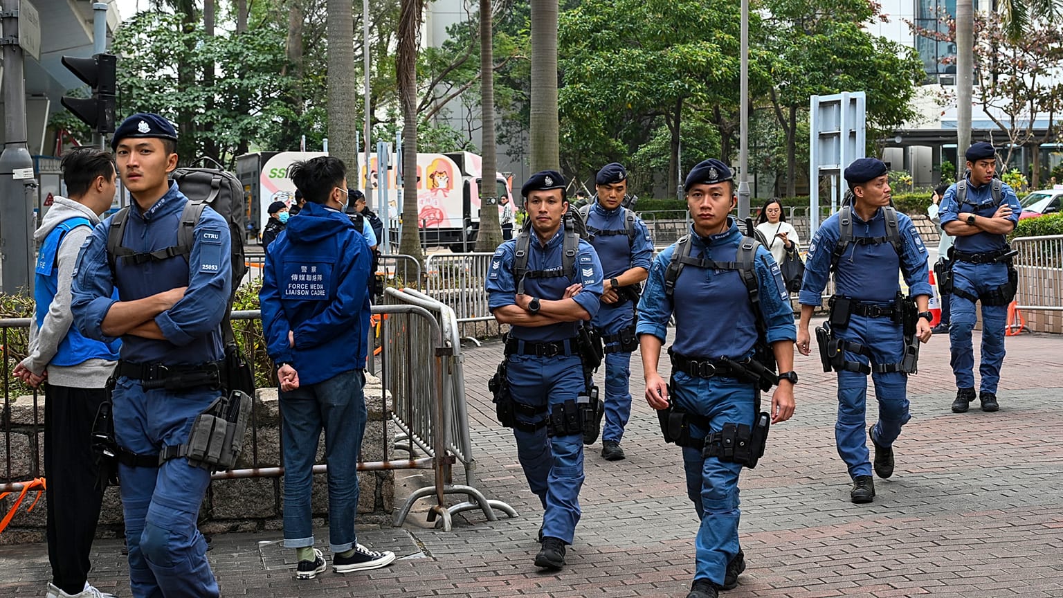 Rendőrök járőröznek a JImmy Lai perének helyet adó bíróség közeklében Hongkongban