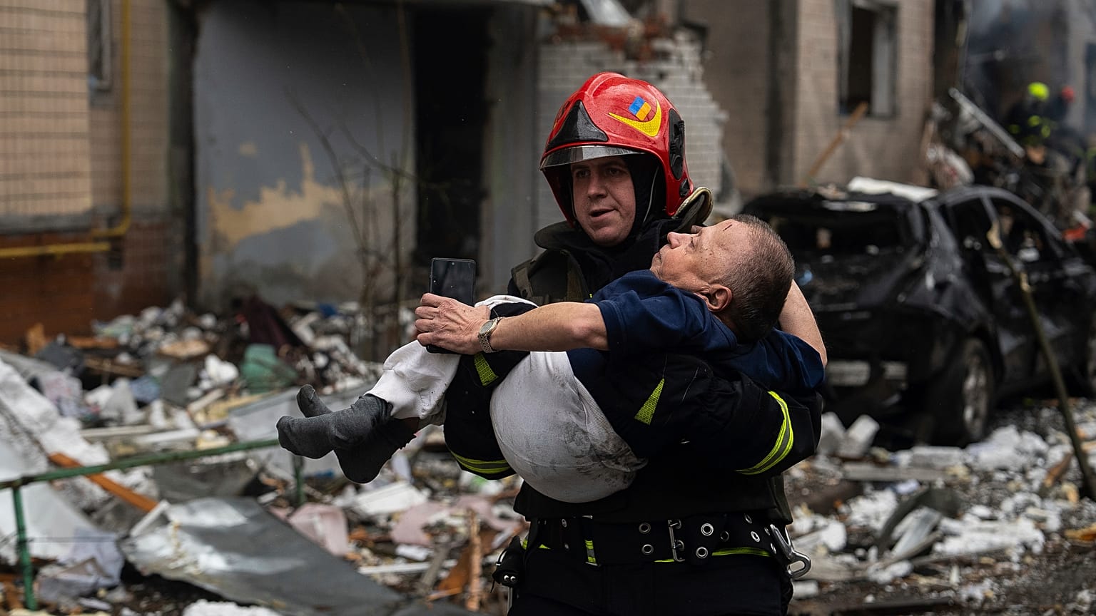 A firefighter carries a man from a damaged residential building after a Russian missile strike, in Kyiv, Ukraine, Tuesday, Jan. 2, 2024.