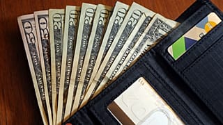 FILE - In this June 15, 2018, file photo, cash is fanned out from a wallet in North Andover, Mass. As you plan your holiday giving, you may be thinking about adding service wo