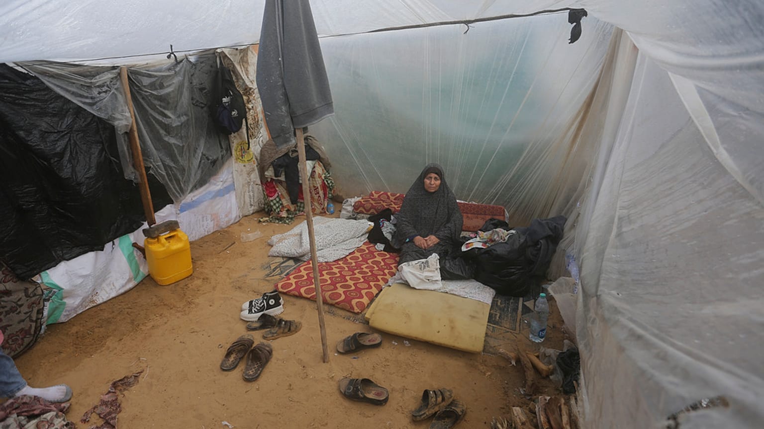 Imagen de una mujer palestina desplazada por los bombardeos israelíes, sentada en una tienda improvisada en Rafah, Franja de Gaza, el martes 2 de enero de 2024.