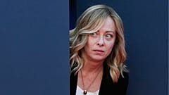 Italy's Prime Minister Giorgia Meloni peers out from a door before introducing Britain's Prime Minister Rishi Sunak at the annual political festival Atreju in December 2023.