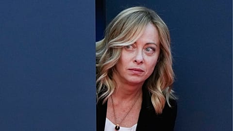 Italy's Prime Minister Giorgia Meloni peers out from a door before introducing Britain's Prime Minister Rishi Sunak at the annual political festival Atreju in December 2023.