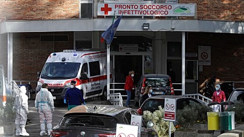 FILE- Paramedics and ambulances stand outside the first aid department of the Cotugno hospital in Naples, Italy, Friday, Nov. 13, 2020. 