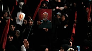 A woman holds up a poster of the late Revolutionary Guard Gen. Qassem Soleimani at the Imam Khomeini grand mosque in Tehran, Iran, Wednesday, Jan. 3, 2024.