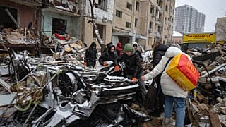 Volunteers and residents clear the debris of an apartment building destroyed by a Russian attack in Kyiv.