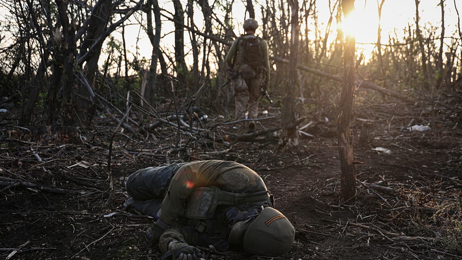 Der Kommandeur der 3. Sturmbrigade "Fedia" geht an der Leiche eines toten russischen Soldaten vorbei.