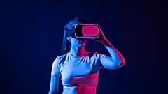 Young woman wearing a virtual reality headset goggles and playing a game in metaverse.