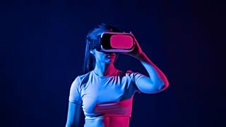 Young woman wearing a virtual reality headset goggles and playing a game in metaverse.