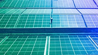 A technician examines solar panels on the roof of a company in Nairobi, September 2023
