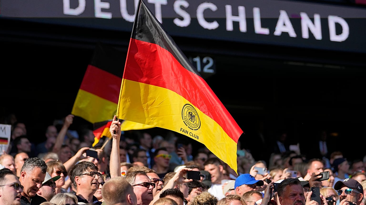 Germany's fans hold a flag during a friendly soccer match between Germany and Ukraine in Bremen, Germany, Monday, June 12, 2023. It is the 1000st match for the German national