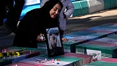 امرأة إيرانية تبكي قرب تابوت لقريب لها قتل في الانفجار