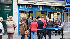 Un grupo de gente hace cola para comprar en Doña Manolita, la administración de lotería más famosa de España.