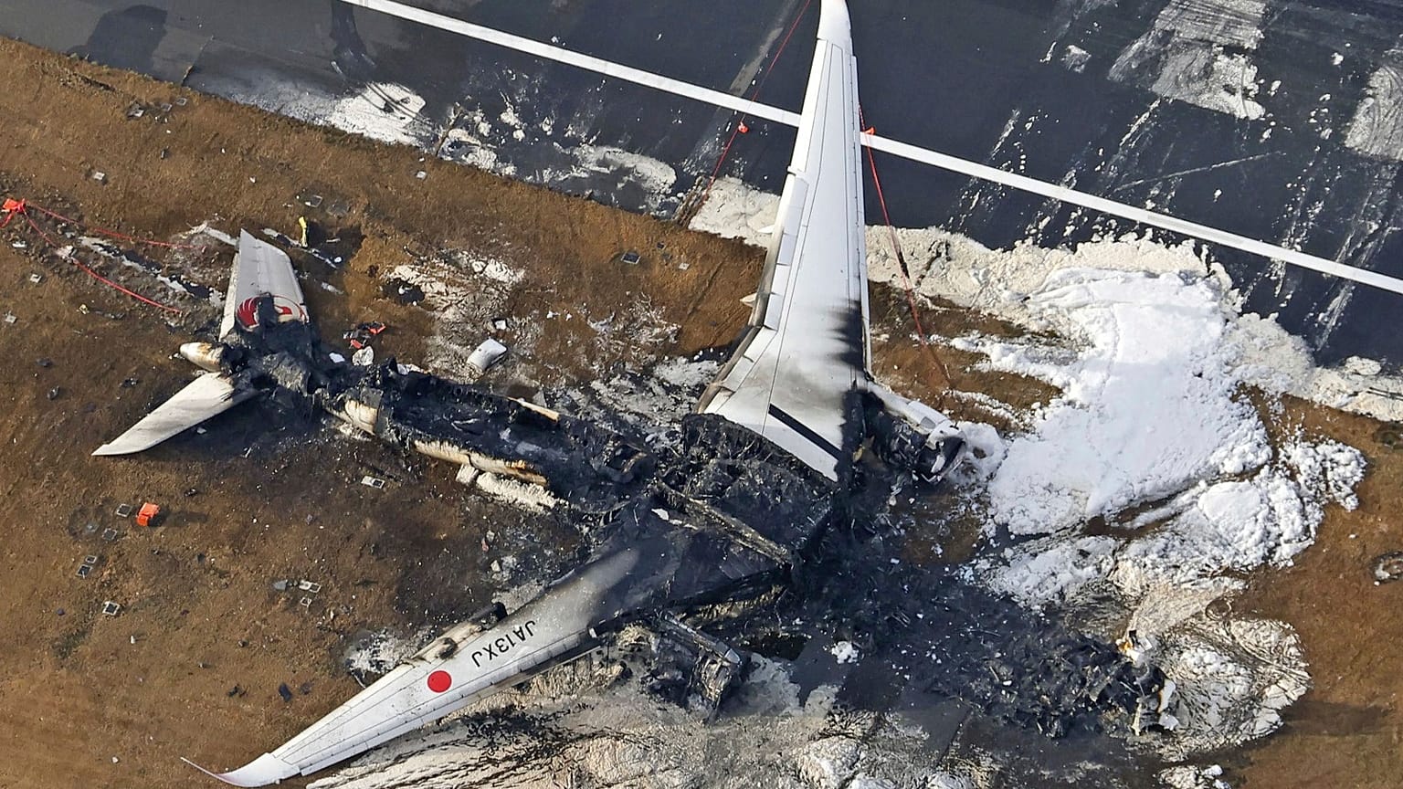 This aerial photo show the burn-out Japan Airlines plane at Haneda airport on Wednesday, January 3, 2024, in Tokyo, Japan.