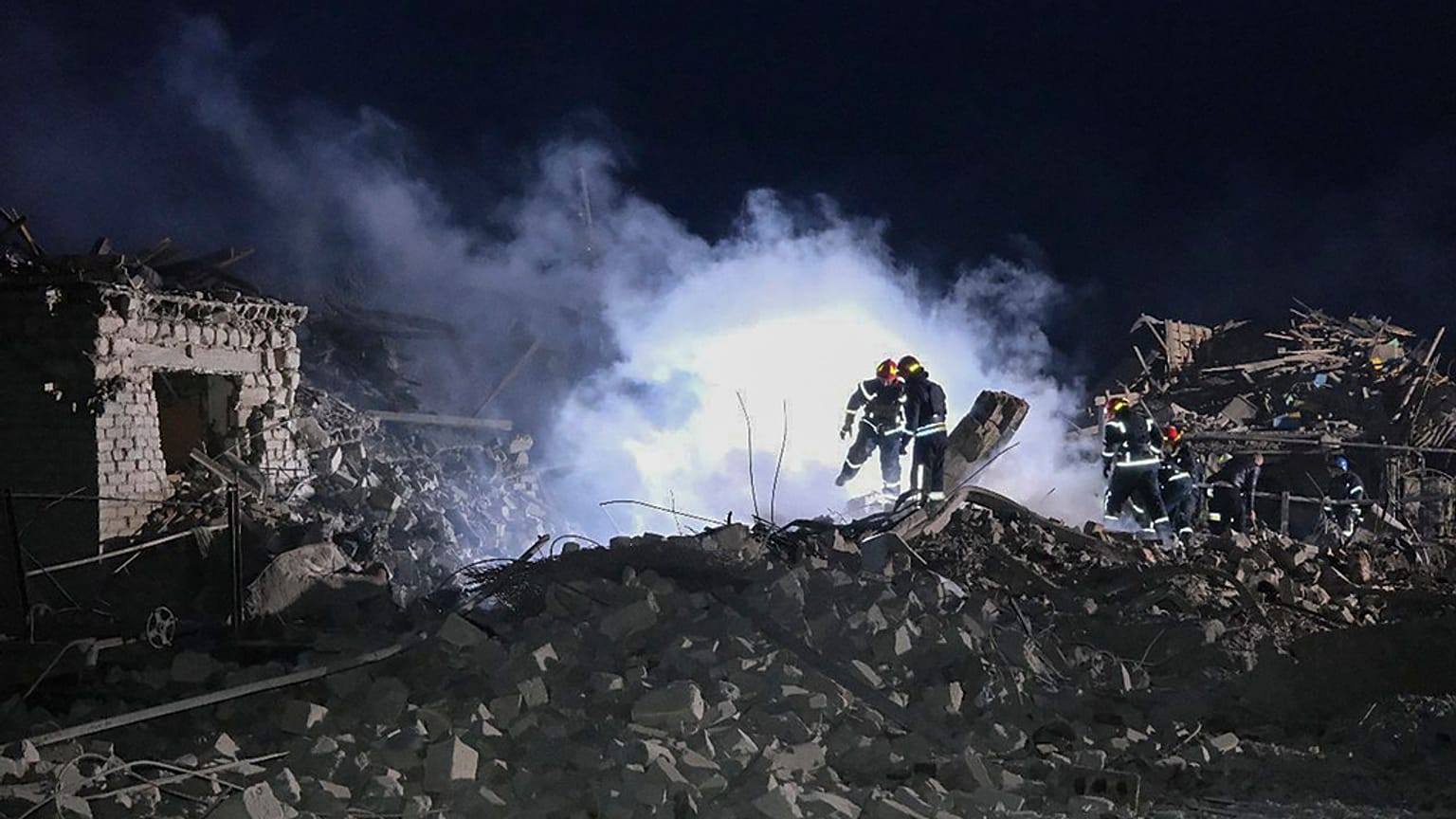 Ukrainian Emergency Service, firefighters examine the site of Russia's missile attack that hit an apartment building in Pokrovsk, Ukraine, late Saturday, Jan. 6, 2024.