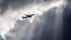 Ein Flugzeug der Air Canada fliegt unter dunklen Wolken, die von einigen Sonnenstrahlen über Frankfurt, Deutschland, beleuchtet werden, Donnerstag, 2. März 2017.
