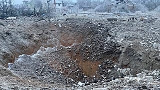 a crater of an explosion is seen next to the private building destroyed after a Russian missile attack in Novomoskovsk, near Kryvyi Rih, Ukraine, Monday, Jan. 8, 2024. 
