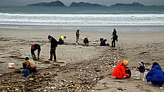 Des volontaires ramassent des billes de plastique sur une plage de Nigran, Pontevedra, Espagne, mardi 9 janvier 2024.