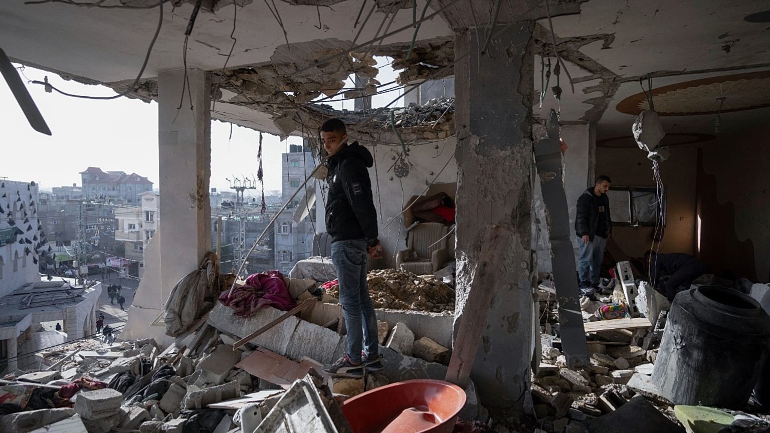 طفل فلسطيني تحت سقف بيت مهدم في رفح في قطاع غزة. 2024/01/10