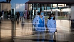 Personas que usan máscaras como medida de precaución caminan dentro de un hospital en Barcelona, España, el lunes 8 de enero de 2024.