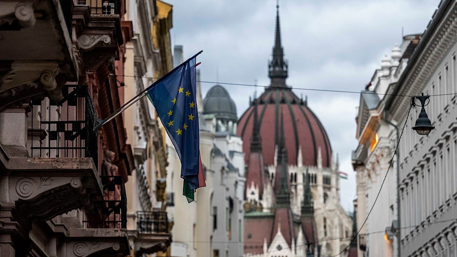 Az Európai Unió zászlaja egy budapesti belvárosi épületen, a háttérben a Parlamenttel 2023. november 20-án