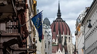 Az Európai Unió zászlaja egy budapesti belvárosi épületen, a háttérben a Parlamenttel 2023. november 20-án