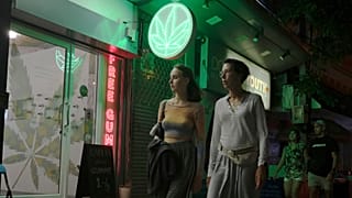 Turistas passam por uma loja de canábis recentemente legalizada, a 10 de agosto de 2022, em Banguecoque, Tailândia.