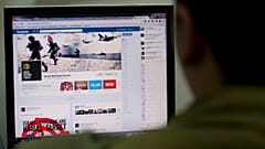 جندي إسرائيلي ينظر إلى صفحة الفيسبوك الخاصة بالجيش الإسرائيلي، في القدس