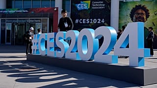 People walk by a CES sign during the CES tech show Wednesday, January 10, 2024, in Las Vegas.