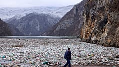 Un operador de grúa camina junto al cimiento de desechos en el río Drina cerca de Visegrad, Bosnia, el 10 de enero de 2024.