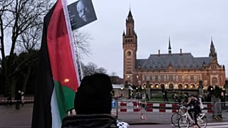 یک طرفدار فلسطینیان در مقابل ساختمان دادگاه در لاهه به تاریخ دوازدهم ژانویه ۲۰۲۴