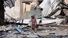 Ein palästinensisches Kind vor Fabriken, die bei der israelischen Bombardierung des Gazastreifens zerstört wurden. Deir al Balah, 13. Januar 2024