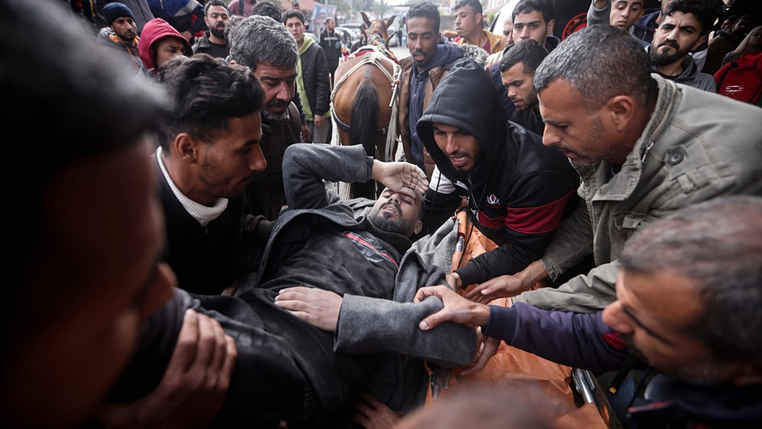 Palestinians evacuate a wounded man after an Israeli strike in Kahan Younis, Gaza Strip