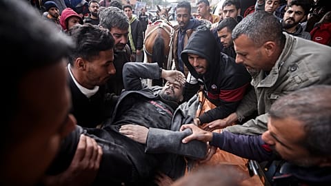 Palestinians evacuate a wounded man after an Israeli strike in Kahan Younis, Gaza Strip