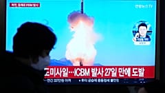 A televízió képernyőjén az észak-koreai rakétaindításról készült felvétel látható egy hírműsor alatt a szöuli vasútállomáson Szöulban, Dél-Koreában vasárnap.