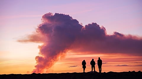 People observe the eruption from the nearby town of Grindavik, Iceland, on 14 January 2024