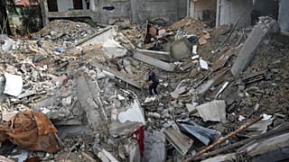 فلسطيني وسط الأنقاض في دير البلح - غزة. 14 يناير 2024.
