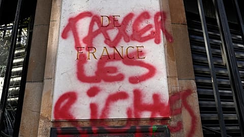 A graffiti reads "Tax the richs" onto the facade of the national French Bank" during a demonstration Thursday, April 13, 2023 in Paris.