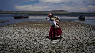 Uma mulher caminha numa parte seca do Lago Titicaca em Coata, Peru, a 29 de novembro de 2023, durante uma onda de calor.