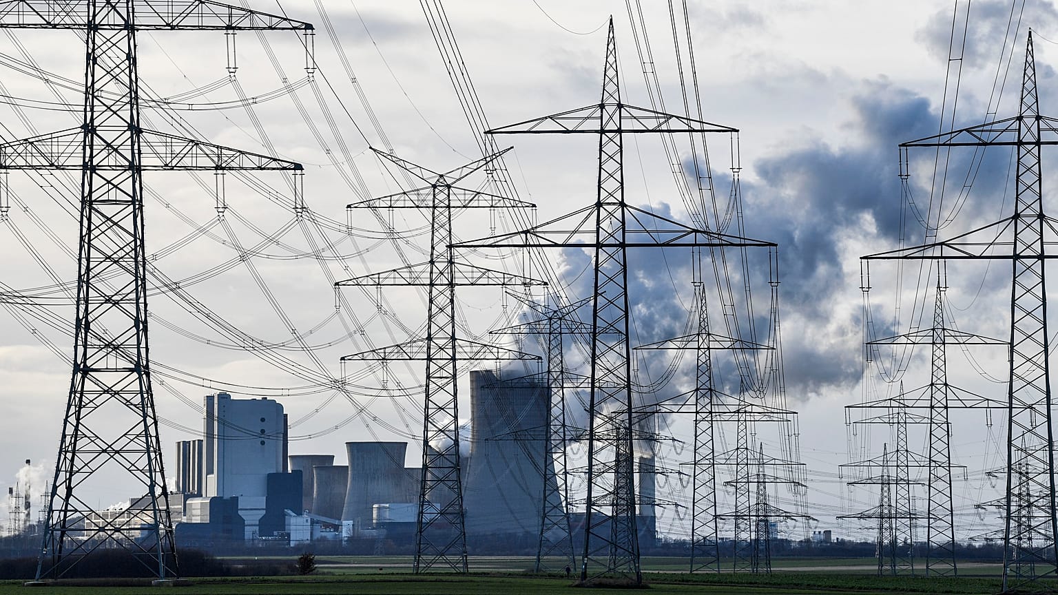  The RWE Niederaussem lignite-fired power station steams behind power poles in Bergheim, Germany, January 2020.