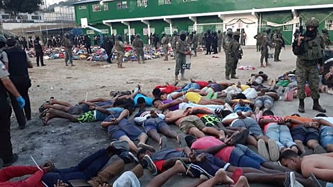 This photo released by Ecuador's Armed Forces shows soldiers standing over prisoners at the prison in Esmeraldas, Ecuador, Sunday, Jan. 14, 2024