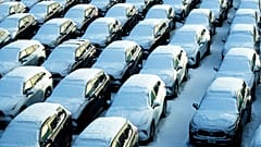 Snow covered vehicles sit in a rental car parking lot at the O'Hare International Airport in Chicago, Sunday, Jan. 14, 2024. 