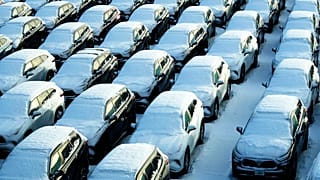 Snow covered vehicles sit in a rental car parking lot at the O'Hare International Airport in Chicago, Sunday, Jan. 14, 2024. 