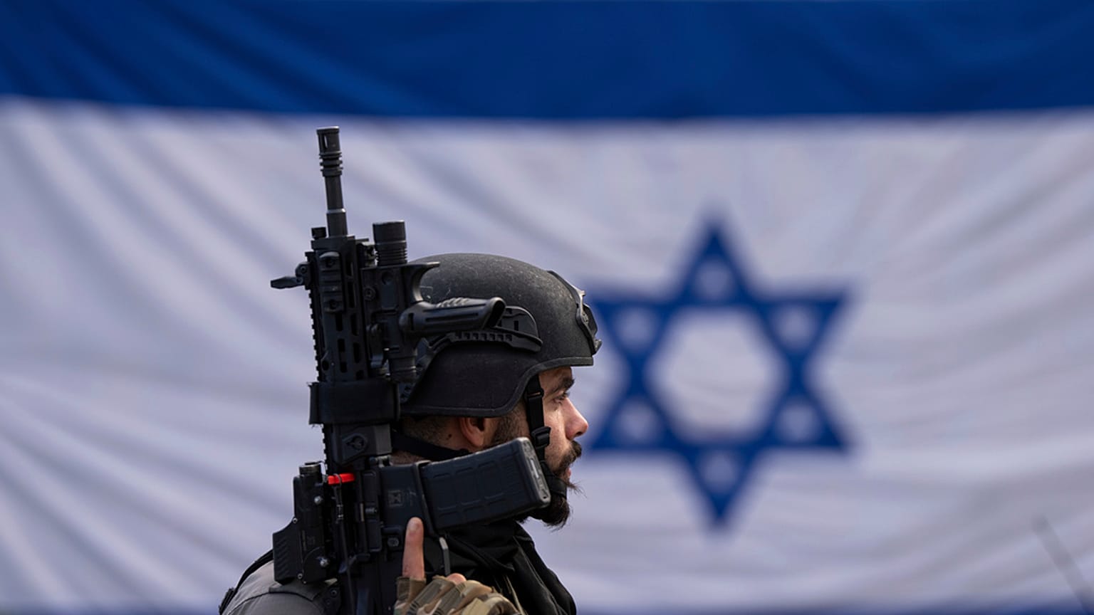 An Israeli border police officer stands guard at  a bus stop in Ra'anana, Israel, Monday, Jan. 15, 2024.