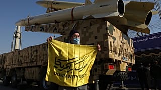 إيراني يحمل شعاراً مناهضاً لأمريكا