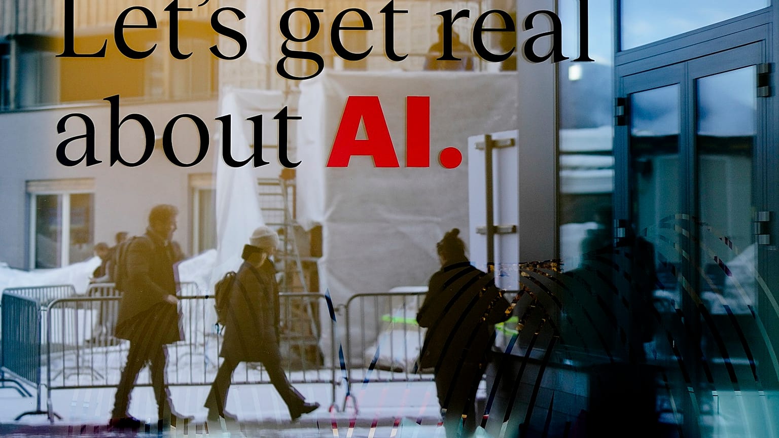 People reflected in a window of a hotel at the Davos Promenade with a slogan about AI alongside the World Economic Forum in Davos, Switzerland, Monday, January 15, 2024.