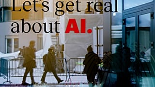 People reflected in a window of a hotel at the Davos Promenade with a slogan about AI alongside the World Economic Forum in Davos, Switzerland, Monday, January 15, 2024.